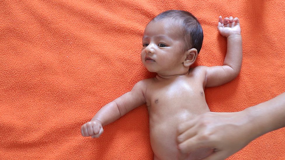 A baby having its tummy rubbed (Credit: Getty Images)