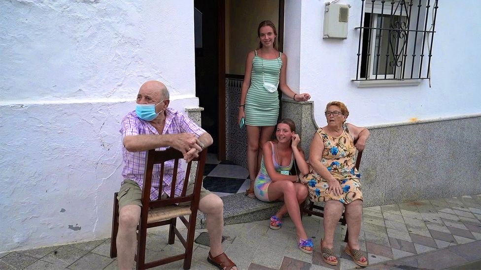 In Algar, people sit outside their doorsteps with friends and relatives