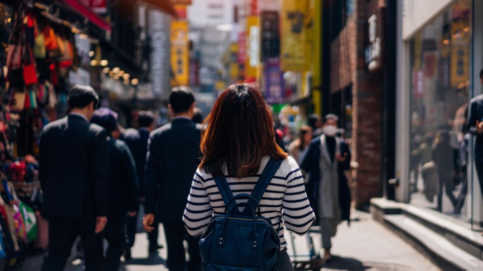 Young woman walking down Myeongdong street market in Seoul, South Korea