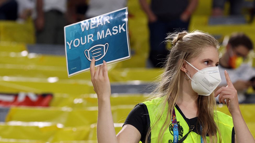 Female steward raising mask sign (Credit: Alexander Hassenstein/Getty Images)