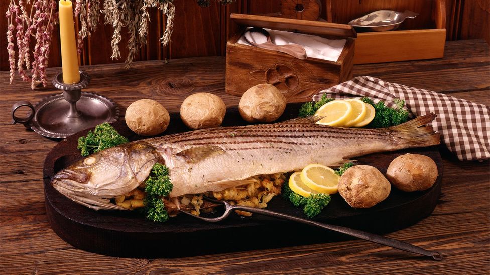 1770s Colonial-era American dish of baked stuffed striped bass garnished with lemon potato parsley (Credit: ClassicStock/Alamy)