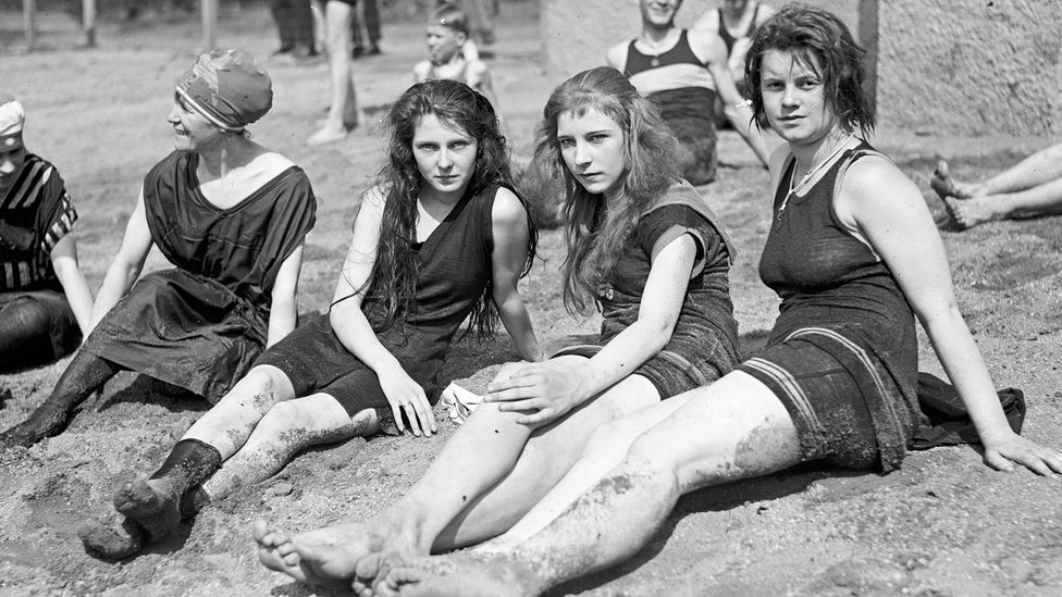 Moody teenagers sitting on a beach (Credit: Getty Images)