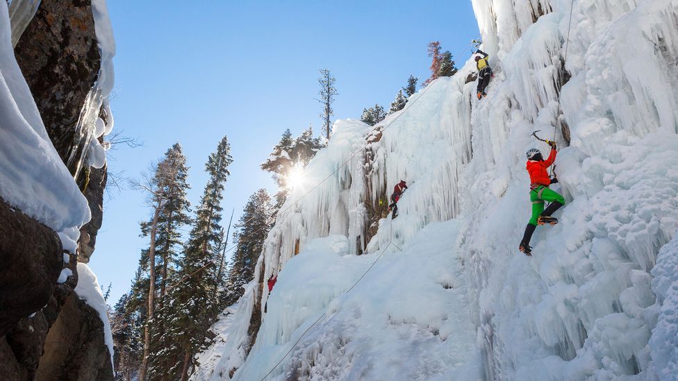 Mountian climbers ascend icy cliffs