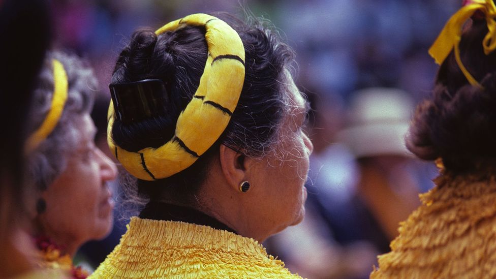A woman wearing yellow feather leis (Credit: Photo Resource Hawaii/Alamy Stock Photo)