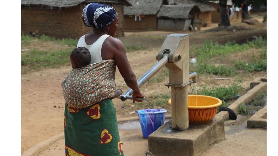 A mother collects water from a pump in Tuglor, Grand Gedeh county (Credit: Peter Yeung)