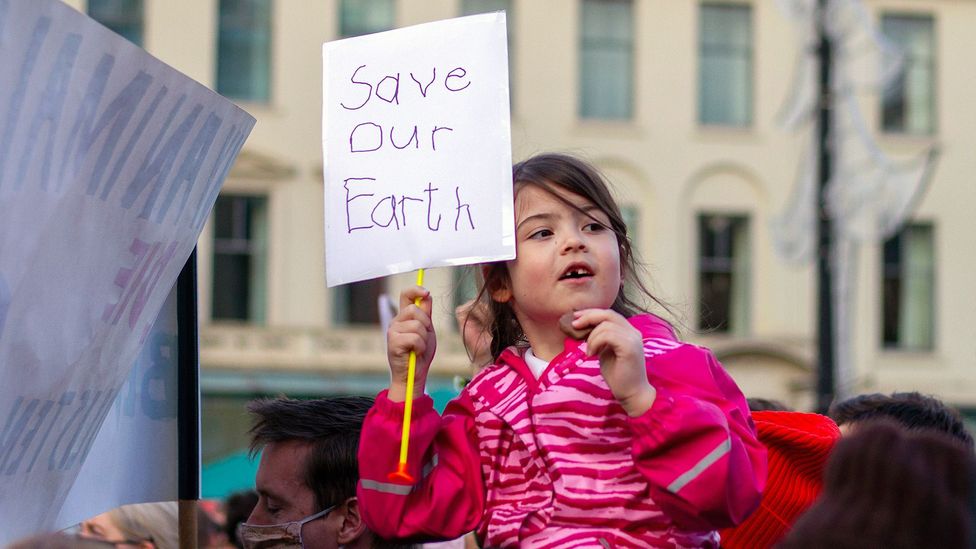 Girl holding "save our earth" sign at climate change protest (Credit: Getty Images)