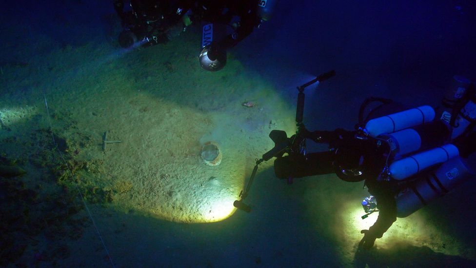 Divers examine war helmets underwater at the site of the Battle of the Aegates (Credit: Jarrod Jablonski/Soprintendenza del Mare)