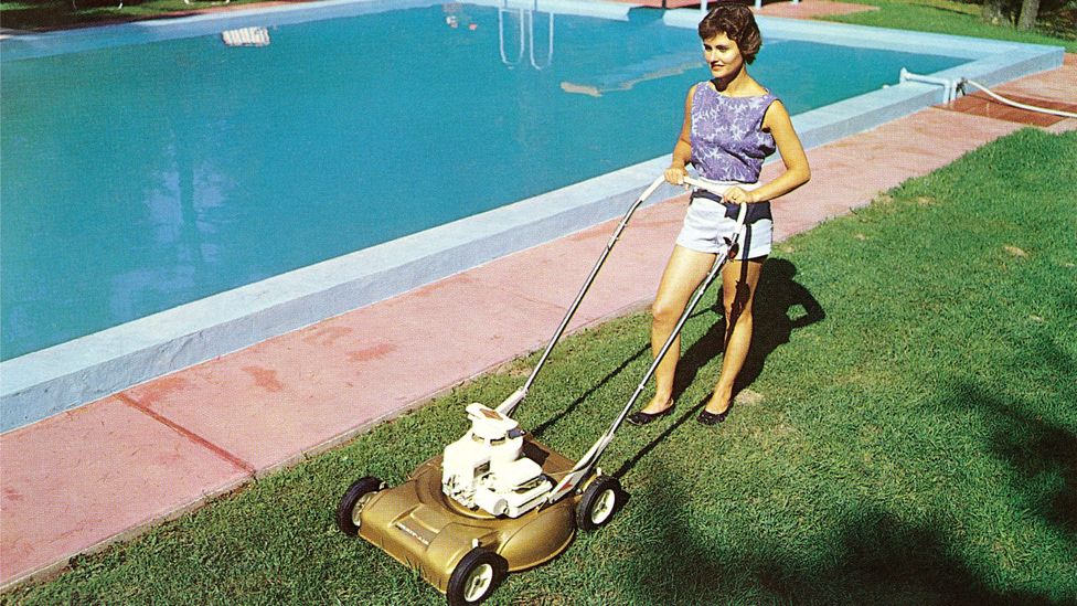 A vintage photograph of a woman mowing a lawn in the 1950s (Credit: Getty Images)
