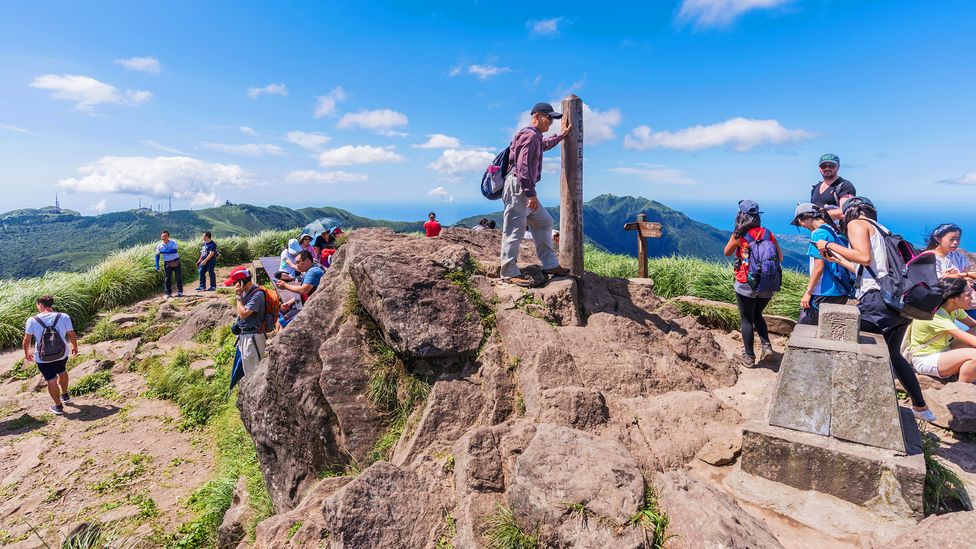 Tourists reach the peak of Cising Mountain in Yangmingshan National Park, a huge expanse of hiking trails lying within Taipei's city limits (Credit: Stockinasia/Alamy)