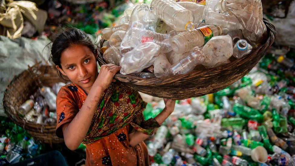 A girl sorts through recycling (Credit: Getty Images)