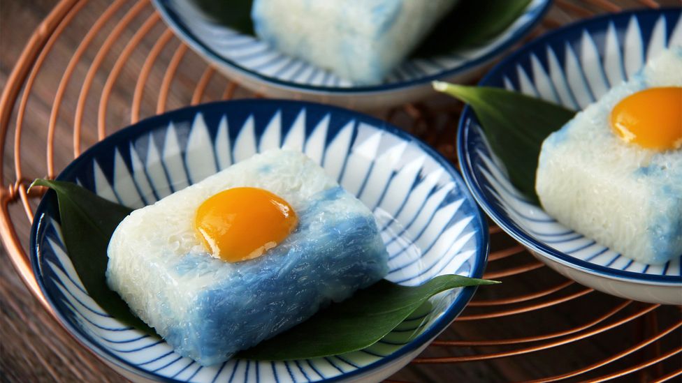 Peranakan desserts come in vivid shades of green, brown, yellow and blue (pictured: pulut tai tai) (Credit: MielPhotos2008/Getty Images)