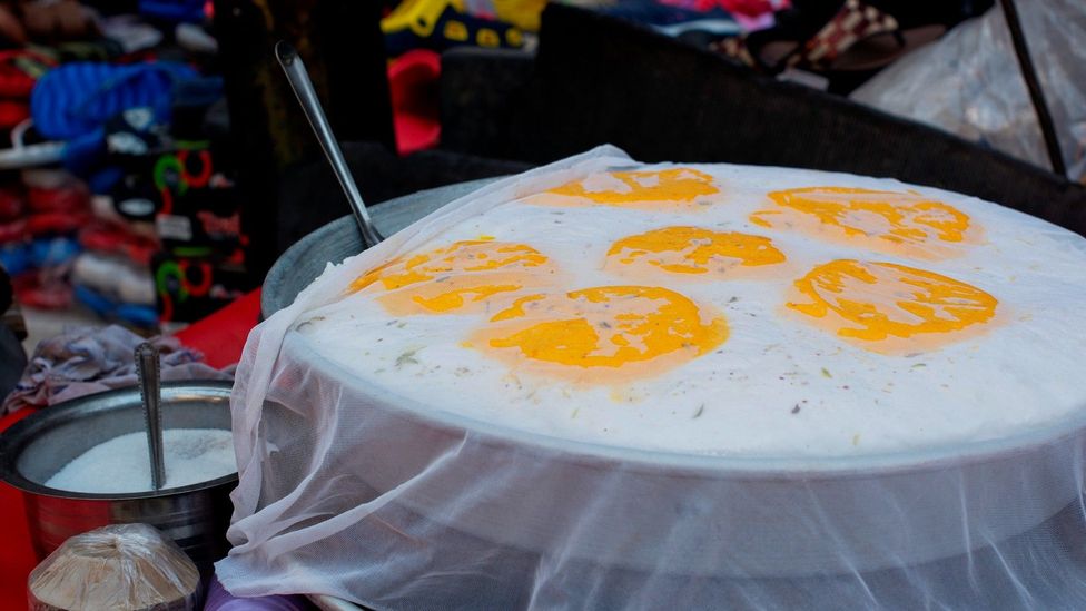 The snack is dolloped with saffron foam and then covered in a fine muslin and set atop slabs of ice (Credit: IndiaPictures/Getty Images)