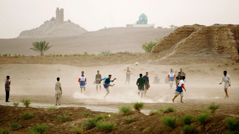 Young Iraqis play soccer in the shadow of the ruins of a ziggurat in Borsippa, Iraq (Credit: Mario Tama/Getty Images)