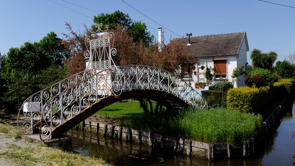 The slender channels of the Hortillonnages are connected by bridges and traversed by boat (Credit: Claude Thibault/Alamy)
