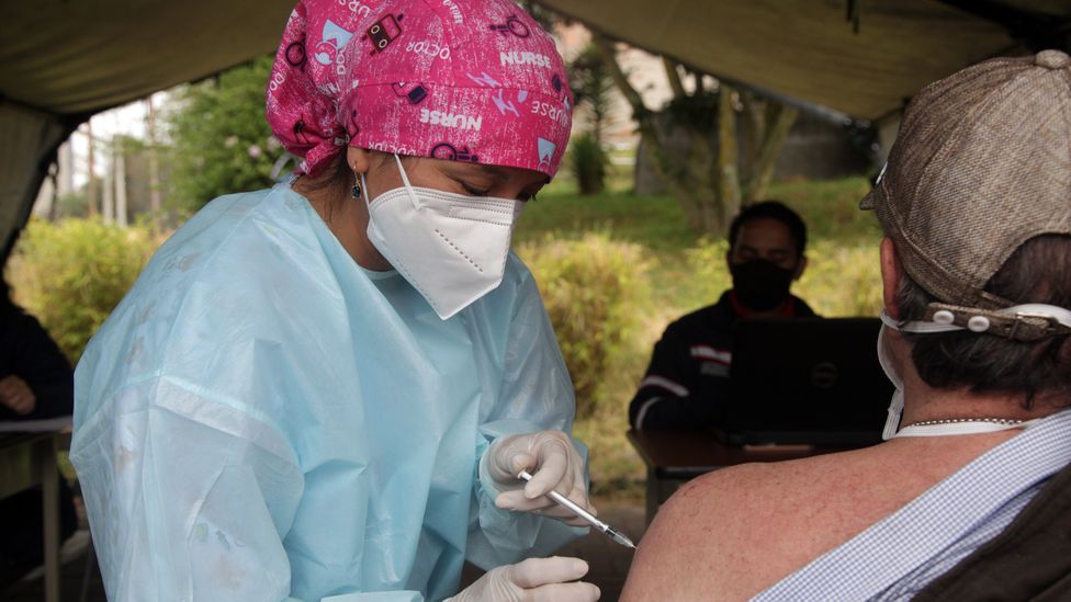 A health worker administering a Covid-19 vaccine in Ecuador, 2022 (Credit: Getty Images)