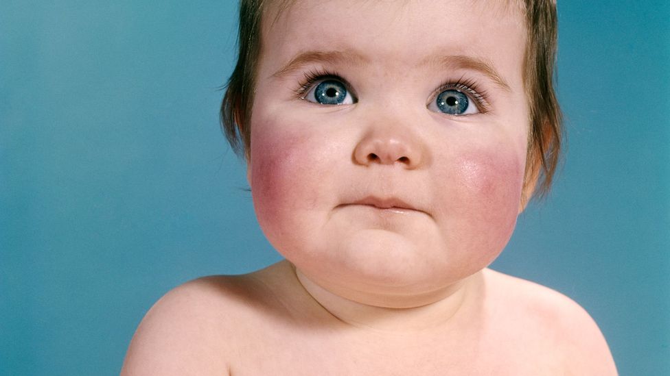 A baby with blue eyes on a blue background (Credit: Getty Images)
