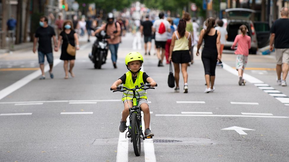 A boy rides a bicycle on a road turned into a pedestrian street on weekends in Barcelona (Credit: Getty Images)