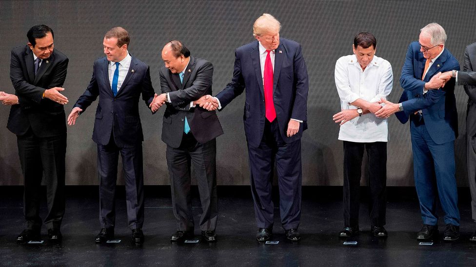 Former US President Donald Trump was briefly flummoxed when leaders were asked to cross hands at a summit in the Philippines in 2017 (Credit: AFP/Getty Images)