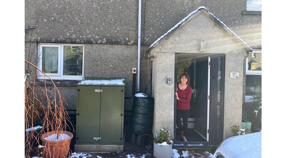 Ceri Simmons' heat pump, seen here outside her house, now supplies all her heat and hot water from a network of pipes under the street (Credit: Evie Townend)