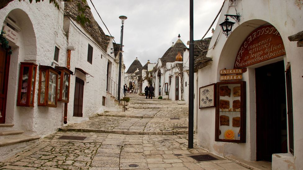 The cobbled walkways in Alberobello are lined with trulli, including this one selling paintings on local olive wood (Credit: Victoria Abbott Riccardi)