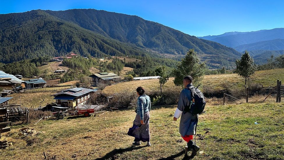 Host Dechen Zangmo and guide Singay Dradul hike near a Bumthang farmhouse (Credit: Nicole Melancon)