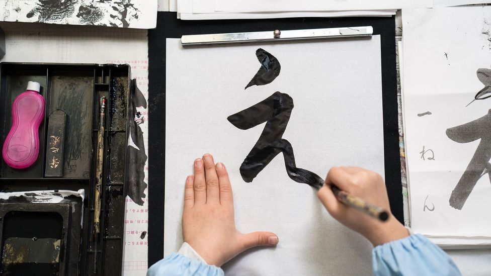 A child practises Japanese calligraphy (Credit: Getty Images)