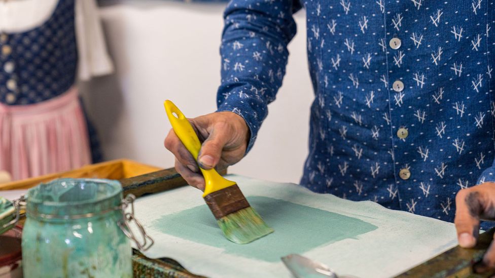 Craftsmen first apply the pattern onto the fabric with the help of the mint-hued, dye-resistant paste (Credit: Yulia Denisyuk)