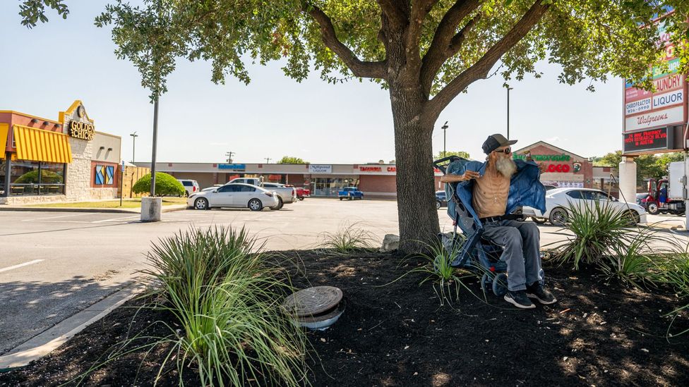 Homeless resident Randy Twede, waits for a bus in July 2023 in Austin, Texas. 'These temperatures are no joke, I'm just trying to survive that's all.' (Credit: Getty Images)