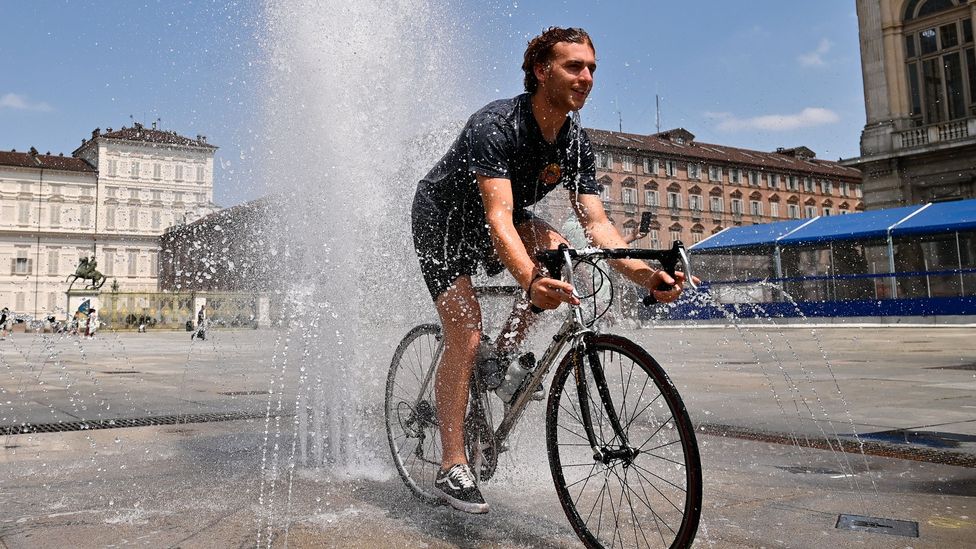 A man rides a bicycle inside a fountain in Piazza Castello on July 11 2023 Turin Italy (Credit: Getty Images)