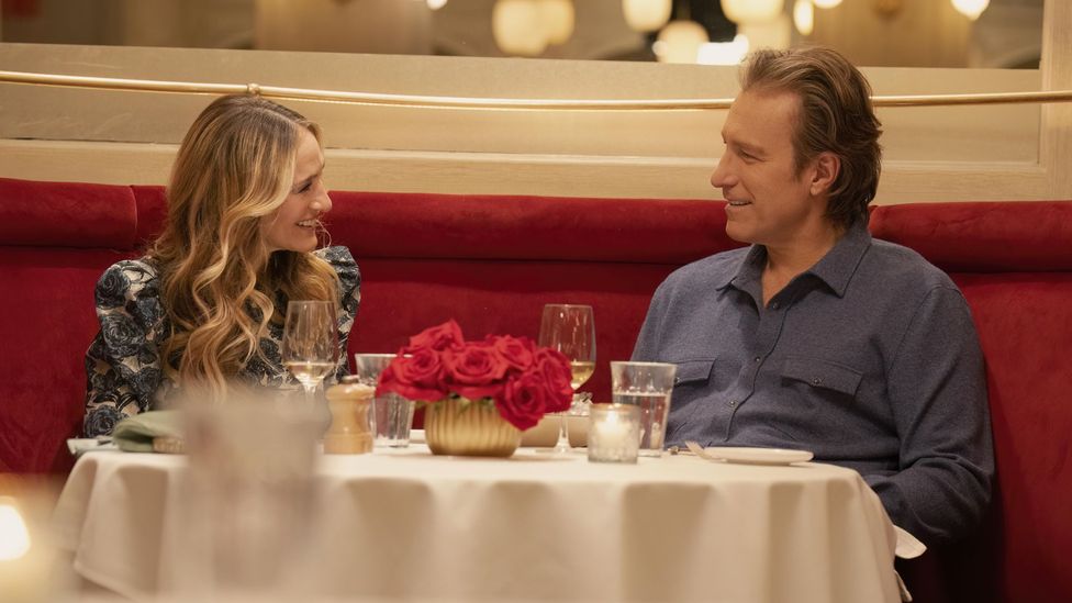 Still of Carrie and Aidan in AJLT laughing at a restaurant table