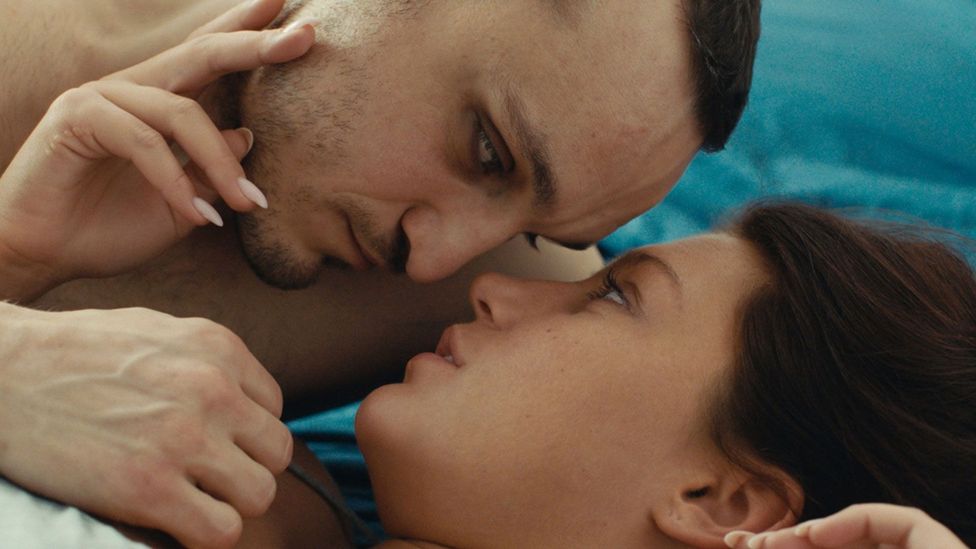 Franz Rogowski and Adèle Exarchopoulos lying together in bed in the film Passages
