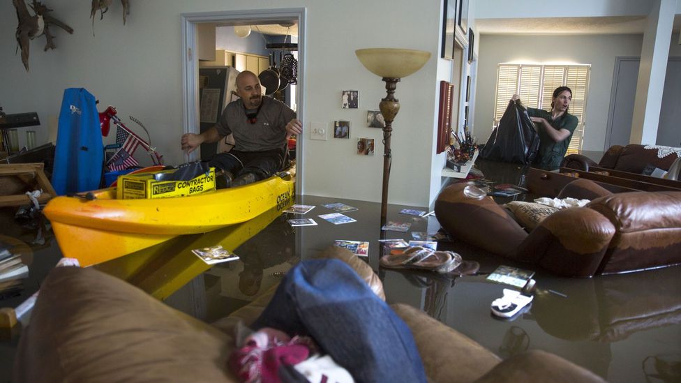 Larry Koser Jr looks with his son for papers and heirlooms in Houston, Texas after his house was flooded by heavy rains from Hurricane Harvey in August 2017 (Credit: Getty Images)