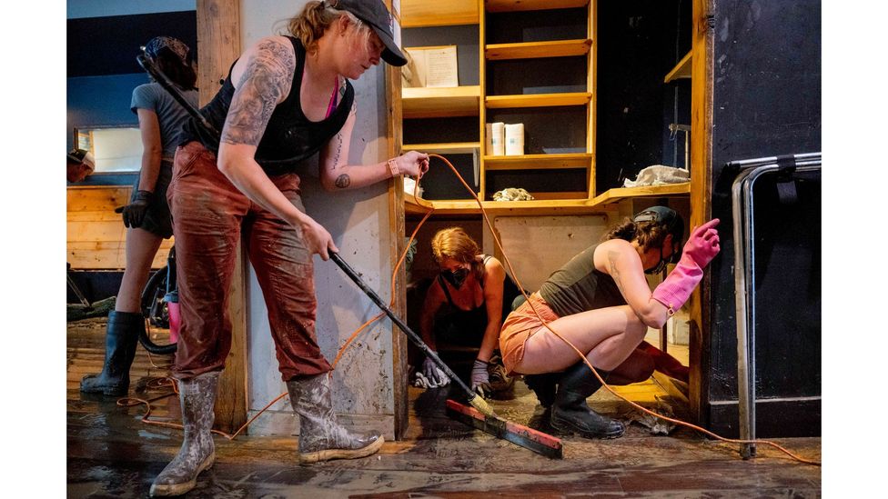 Clara Walsh, Rachel Farrell and Erika McCormick help clean up Three Penny Taproom in Montpelier, Vermont, after damage due to major flooding in July 2023 (Credit: Getty Images)