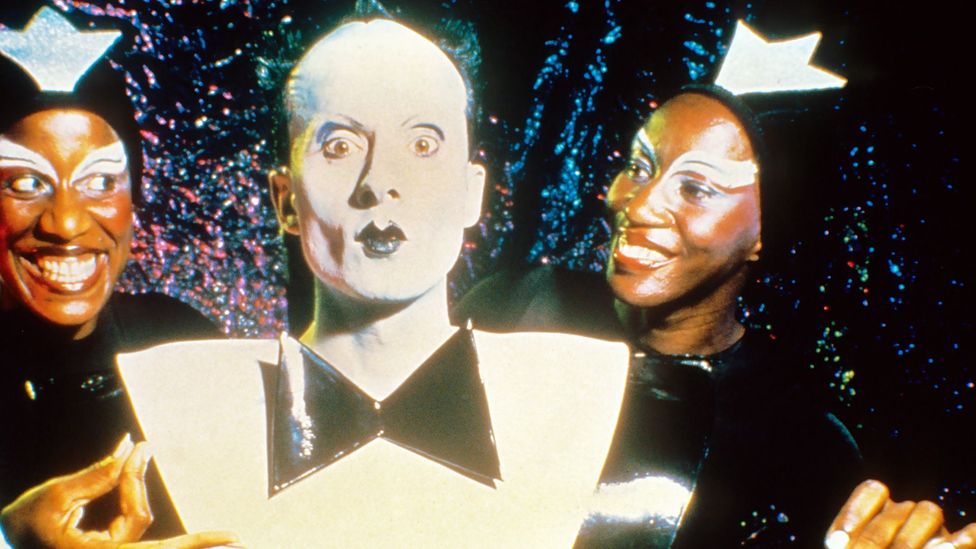 Performance artist and singer Klaus Nomi in his famous black-and-white suit with two backing performers