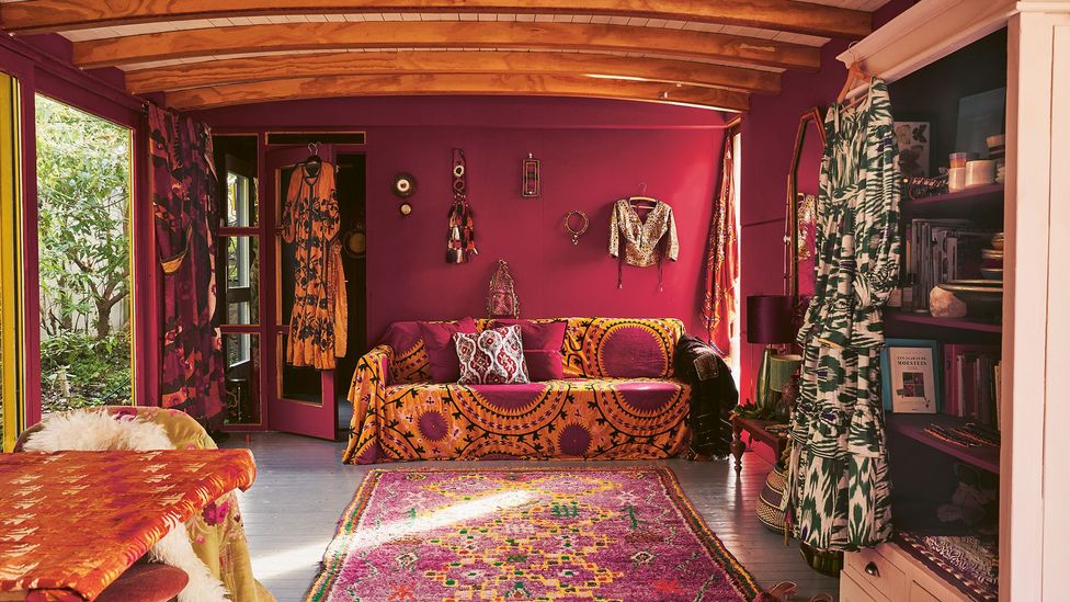 Wooden houseboat Zazi dates from the 1970s, and is moored in an Amsterdam suburb – its occupant has brightened it up with a saffron and crimson interior (Credit: Muk Van Lil)