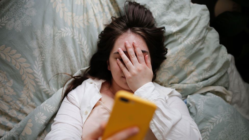 Girl looking at phone with hand on face