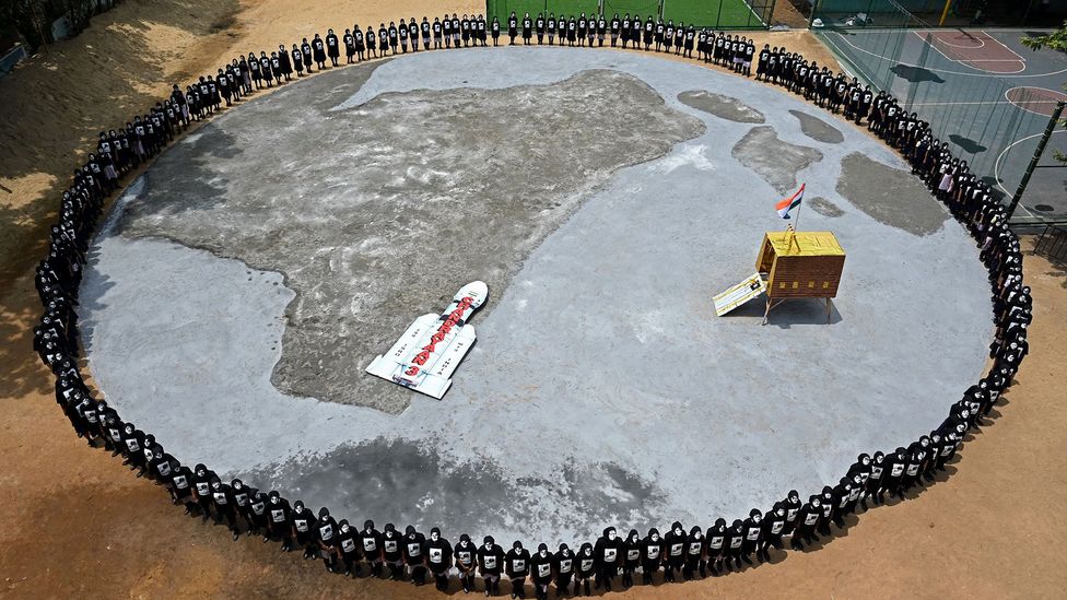School children wearing face paint form a ring around a model of the Vikram lander (Credit: Getty Images)