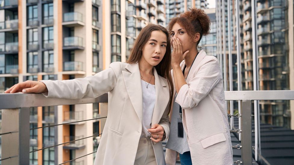 Colleagues whispering to each other