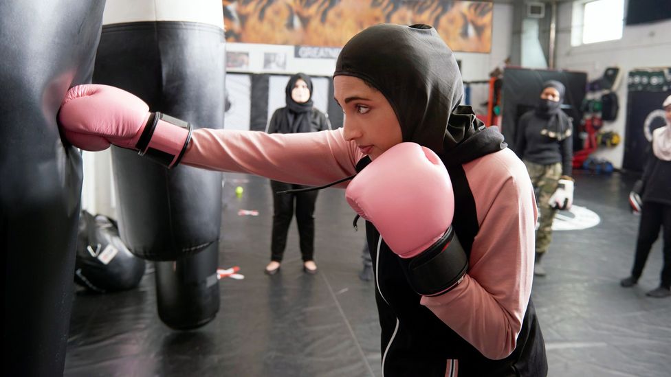 Woman with boxing gloves and punching bag