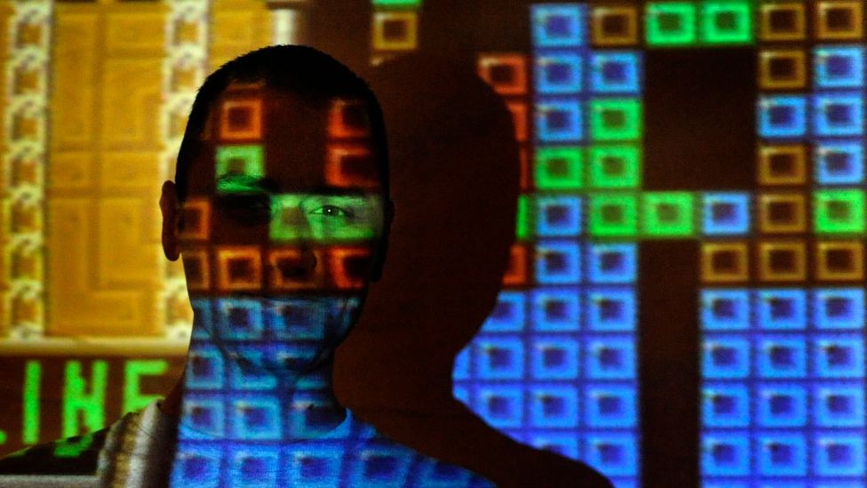 An image of Tetris game is projected over a man's face (Credit: Getty Images)
