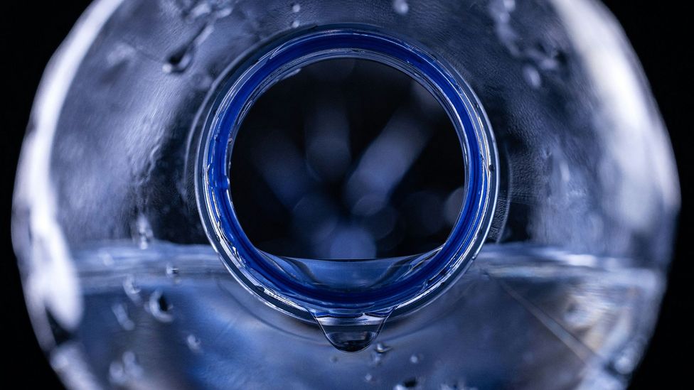 Close up of water pouring from the mouth of a plastic bottle (Credit: Getty Images)