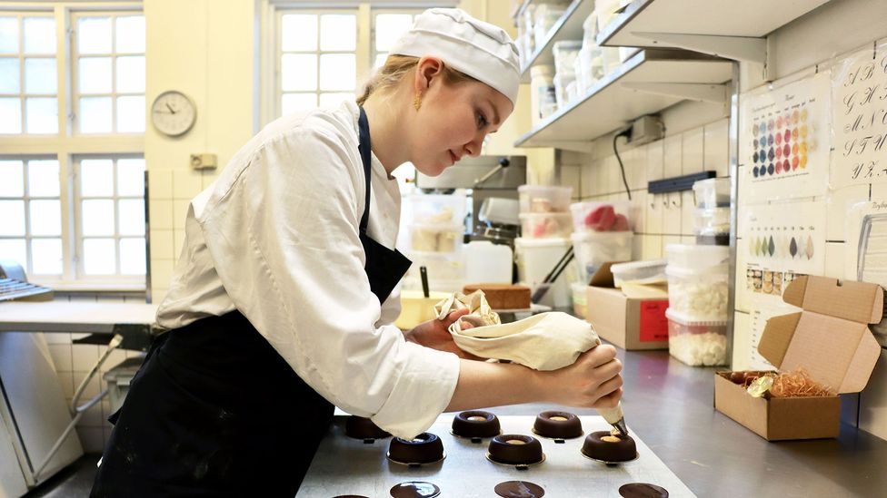 Trainee chef Amelia Heimann pipes hazelnut paste and salted caramel into the centre of each cake (Credit: Adrienne Murray Nielsen)