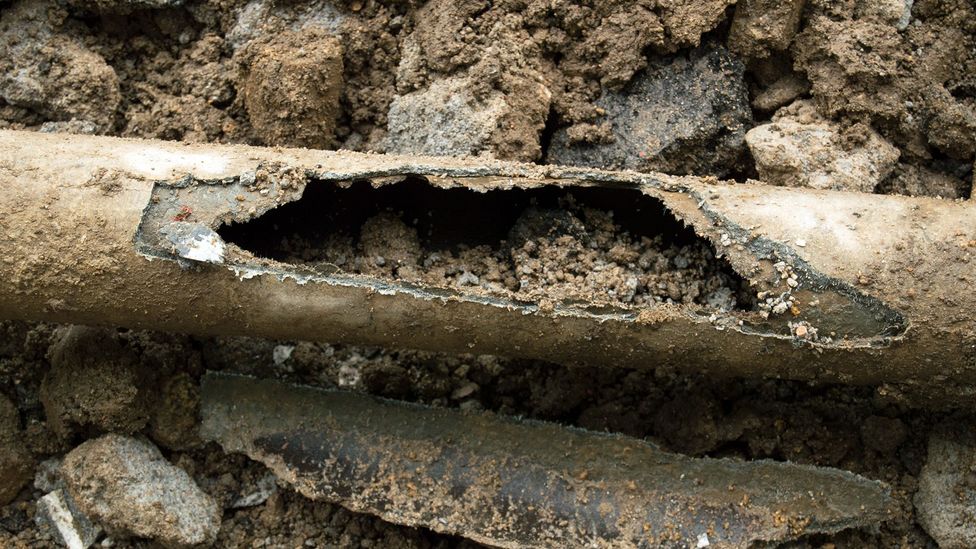 A broken asbestos cement pipe in the ground (Credit: Getty Images)