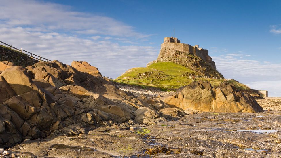 Lindisfarne Castle with rock pool in foreground