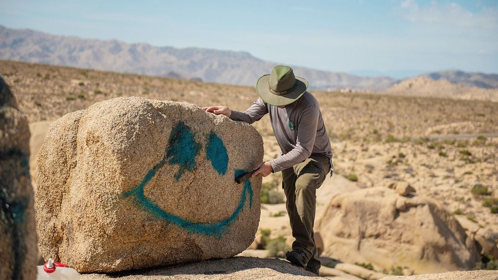 Person spray-painting rock (Credit: Alamy)