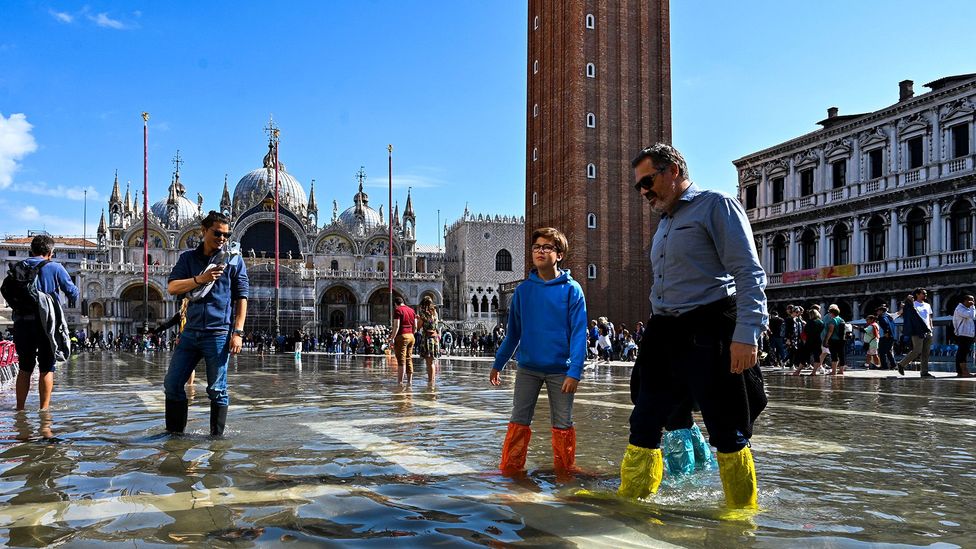 Tourists in flooded square in Venice (Credit: Getty Images)