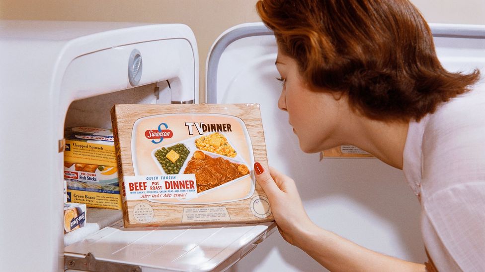 Woman taking 1950s TV dinner out of freezer (Credit: Getty Images)