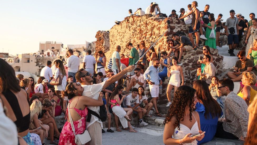 Crowds of tourists watching the sunset in Oia, Santorini (Credit: Getty Images)