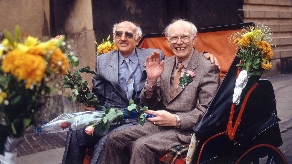 Two men sitting on a cart surrounded by flowers (Credit: Getty Images)