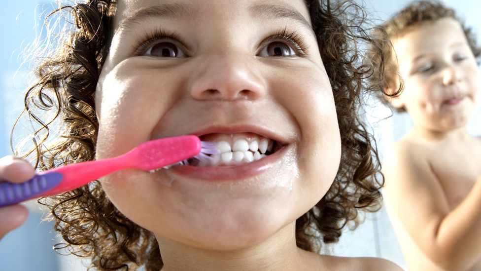 Children brush their teeth using a manual plastic toothbrush (Credit: Getty Images)